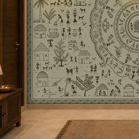 A large wall mural featuring intricate black tribal-style illustrations on a pale sage green background, shown installed in a warm-toned interior hallway with a wooden cabinet, lamp, and rug.