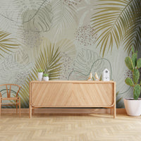 An architectural perspective of a contemporary living room featuring the Whispering Palms Mural in Tea Green as a full-scale feature wall. The mural’s light green and neutral gray tones pair elegantly with a cream-colored fabric sofa, light oak furniture, and minimalist decor, creating a serene and balanced interior sanctuary.