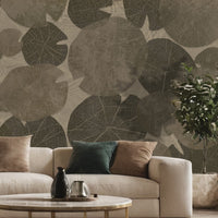 A high-resolution detail of the Whispers of the Pond Nature Wallpaper, showcasing the intricate, lace-like skeletal structures and detailed veining of the overlapping lily pads. The image highlights the sophisticated interplay between the dark charcoal leaf patterns and the warm, textured beige background.