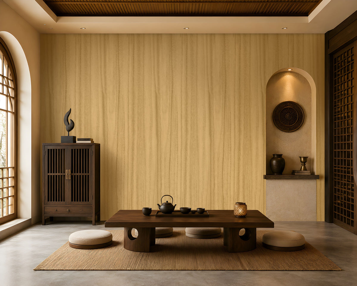Wood Seamless Wallpaper - Golden Beige displayed in a serene Japandi-inspired living space. The wallpaper features a warm golden beige tone with delicate vertical wood grain textures, creating a seamless and natural backdrop. Paired with dark wood furniture, floor cushions, decorative pottery, ambient lighting, and earthy accents, the design brings warmth, texture, and timeless elegance to the interior.