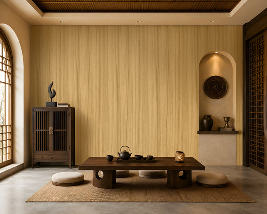 Wood Seamless Wallpaper - Golden Beige displayed in a serene Japandi-inspired living space. The wallpaper features a warm golden beige tone with delicate vertical wood grain textures, creating a seamless and natural backdrop. Paired with dark wood furniture, floor cushions, decorative pottery, ambient lighting, and earthy accents, the design brings warmth, texture, and timeless elegance to the interior.