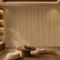 Wood Seamless Wallpaper - Wheat Cream displayed in a cozy contemporary interior. The wallpaper features a warm wheat cream tone with subtle vertical wood grain textures, creating a soft and natural backdrop. Complemented by warm ambient lighting, wooden accents, decorative shelving, and neutral furnishings, the design brings a sense of depth, comfort, and understated elegance to the space.