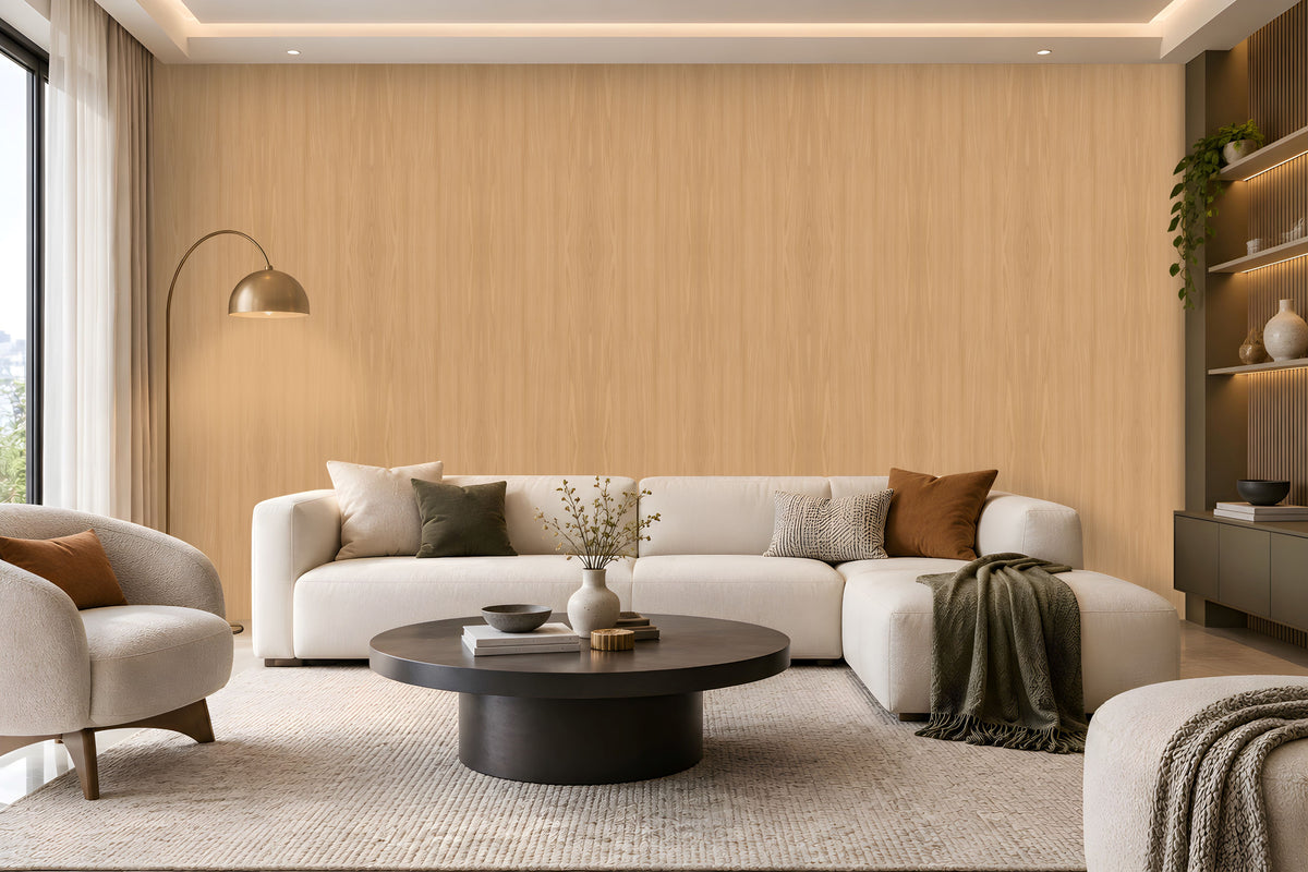Warm Sand Wood Seamless Wallpaper featuring a subtle natural wood grain texture in soft beige and warm sandy tones, creating a calm, elegant, and sophisticated interior wall finish. The seamless vertical wood pattern adds gentle depth and a natural organic feel while maintaining a clean and refined appearance. The wallpaper is showcased across a spacious feature wall in a bright contemporary living room with neutral cream furniture, a dark round coffee table, textured rug, earthy brown cushion