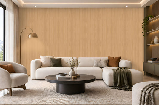 Warm Sand Wood Seamless Wallpaper featuring a subtle natural wood grain texture in soft beige and warm sandy tones, creating a calm, elegant, and sophisticated interior wall finish. The seamless vertical wood pattern adds gentle depth and a natural organic feel while maintaining a clean and refined appearance. The wallpaper is showcased across a spacious feature wall in a bright contemporary living room with neutral cream furniture, a dark round coffee table, textured rug, earthy brown cushion